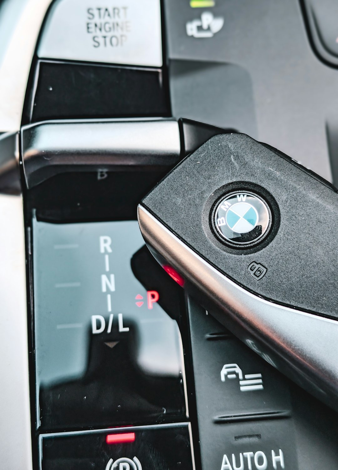 Black BMW key fob resting on a modern car console.